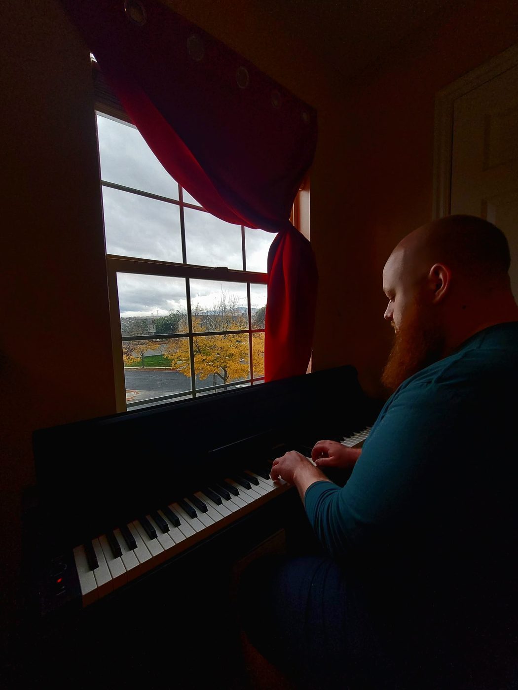 Ashton playing piano by the window